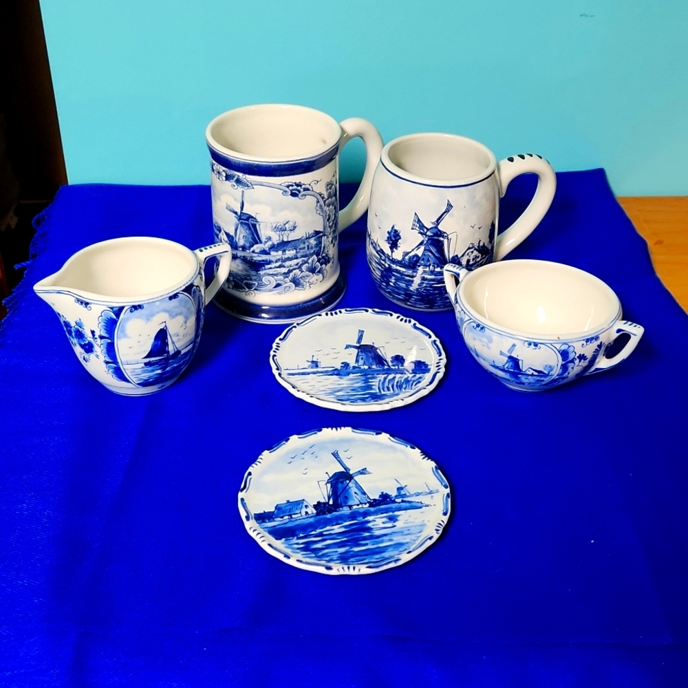 Six Delft Pieces, large and small mugs, creamer, sugar dish, two wall plaques.